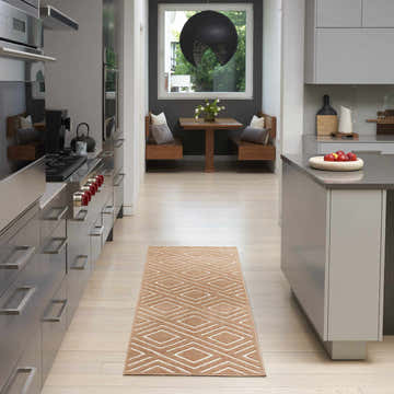 Modern kitchen with stainless steel appliances and Nourison Care Free Copper rug runner with geometric pattern.