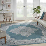 Bright sunroom with white desk, couch, and Nourison Passion Turquoise Grey Bohemian rug with a central medallion pattern.