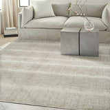 Modern living room with a Calvin Klein CK079 Notes Ivory Grey rug, neutral sofa, and concrete side tables.