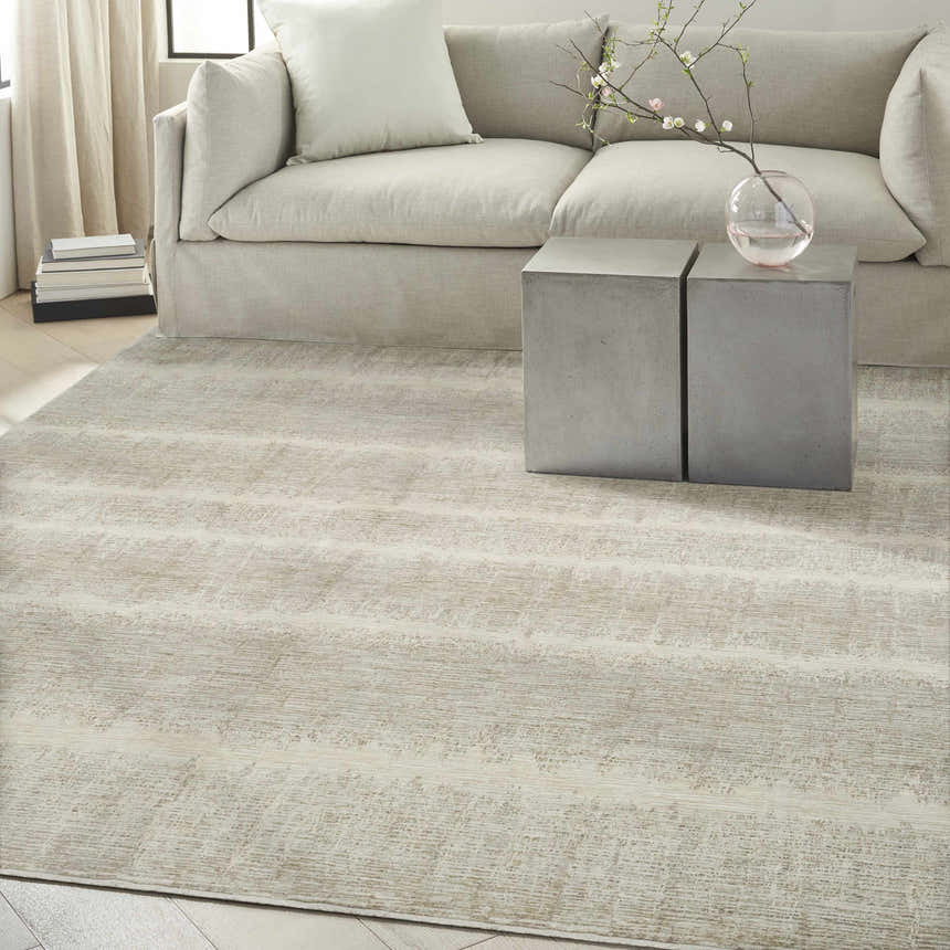 Modern living room with a Calvin Klein CK079 Notes Ivory Grey rug, neutral sofa, and concrete side tables.