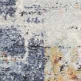Close-up of Nourison Motion Blue Multicolor rug showing low pile texture and abstract blue, gold, and cream pattern.