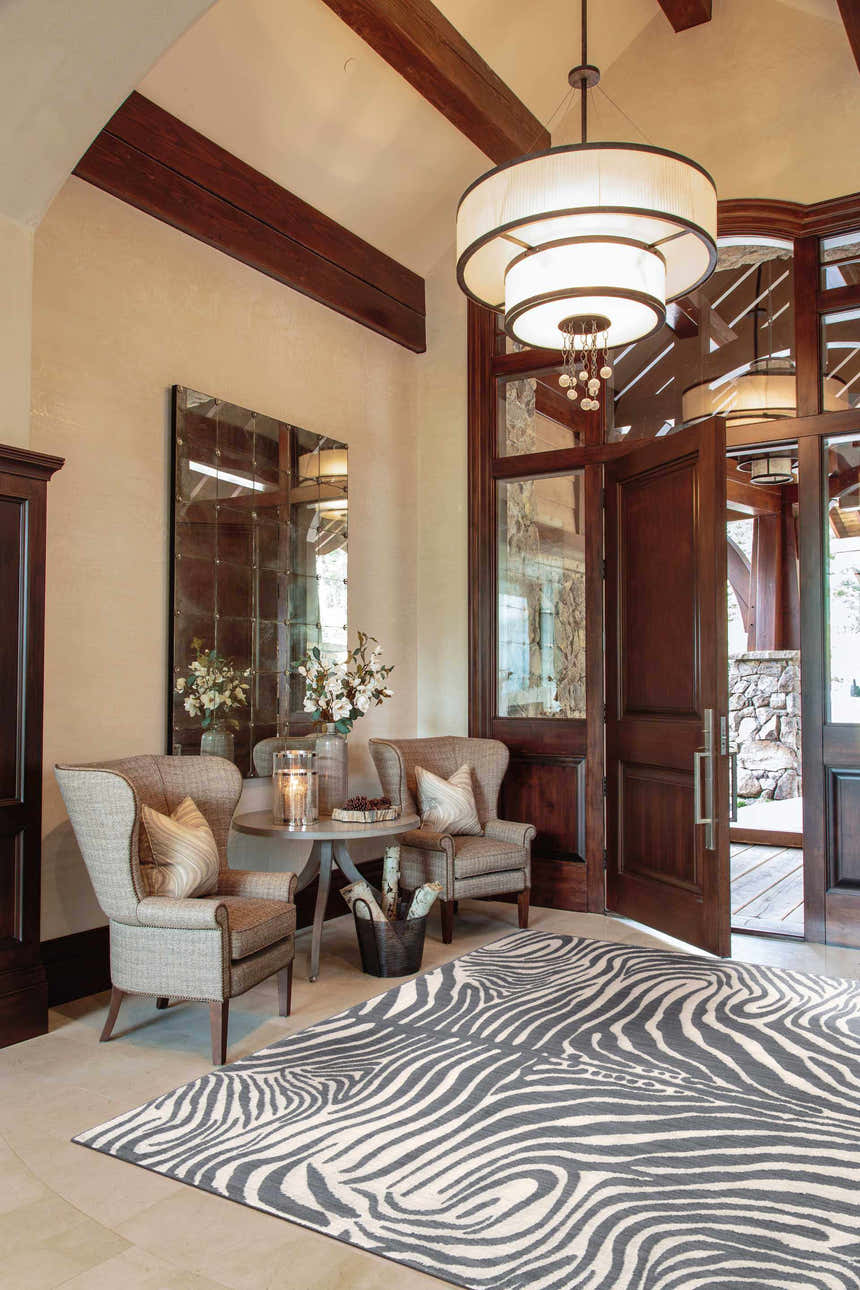 Entryway with wingback chairs and Barclay Butera Madagascar Graphite rug. The rug has a gray and white zebra print.