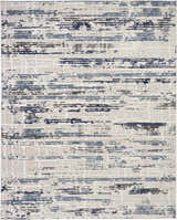 Close-up of Nourison Urban Decor Ivory/Slate rug. Modern design with chestnut, blue, and gray abstract pattern on an ivory base.