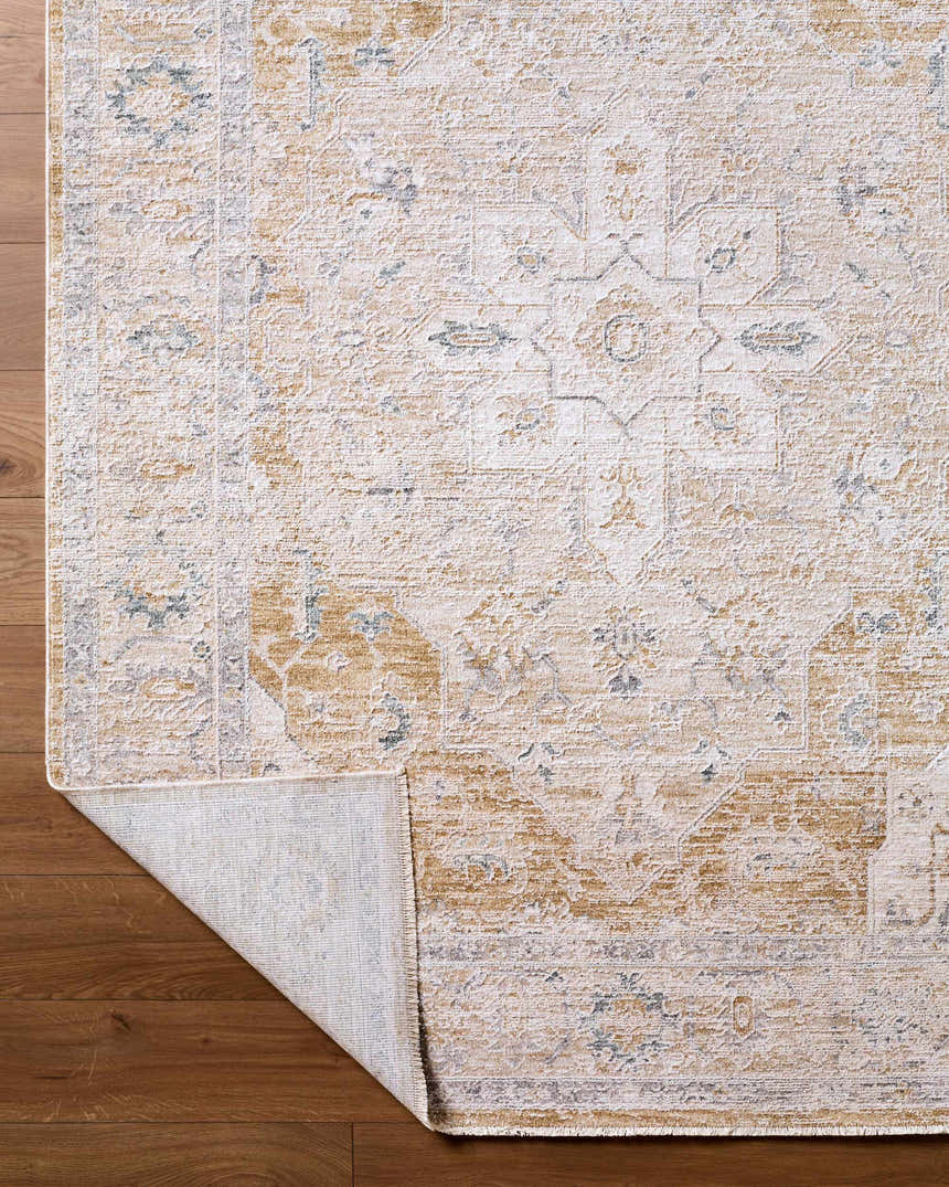 Close-up of the Rhody Luxe Rug, a traditional rug in light silver and sterling gray, on a wood floor. Fold