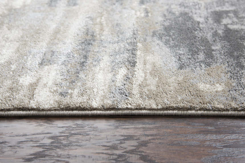 Close-up of the Rizzy EN7258 area rug showing beige, gray, and ivory abstract pattern and textured pile on wood floor. Pile