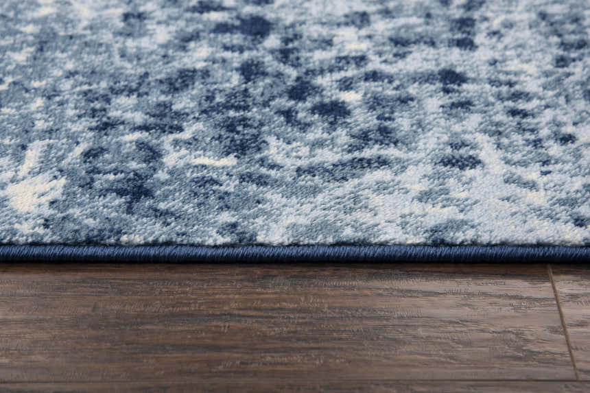 Close up of the Rizzy EN7262 area rug. Contemporary design in blue, ivory, and navy on a soft, textured pile. Pile