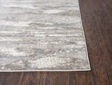 Close up of the Rizzy EN7264 area rug showing its beige, ivory, light brown, and light gray contemporary pattern. Corner