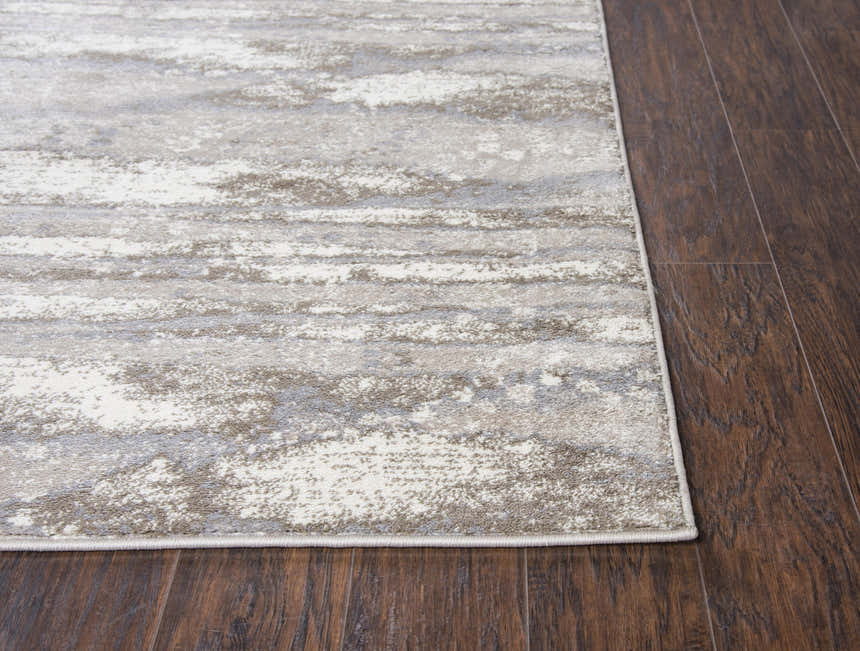 Close up of the Rizzy EN7264 area rug showing its beige, ivory, light brown, and light gray contemporary pattern. Corner