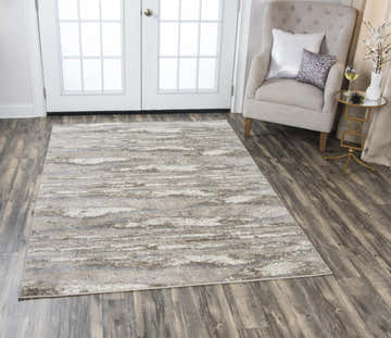 Entryway scene with a beige Rizzy EN7264 area rug, accent chair, and wood floors. Roomscene-Rectangle