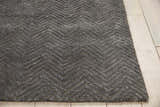 Close-up of the grey Nourison Deco Mod rug, featuring a modern, textured chevron pattern on light wood flooring.