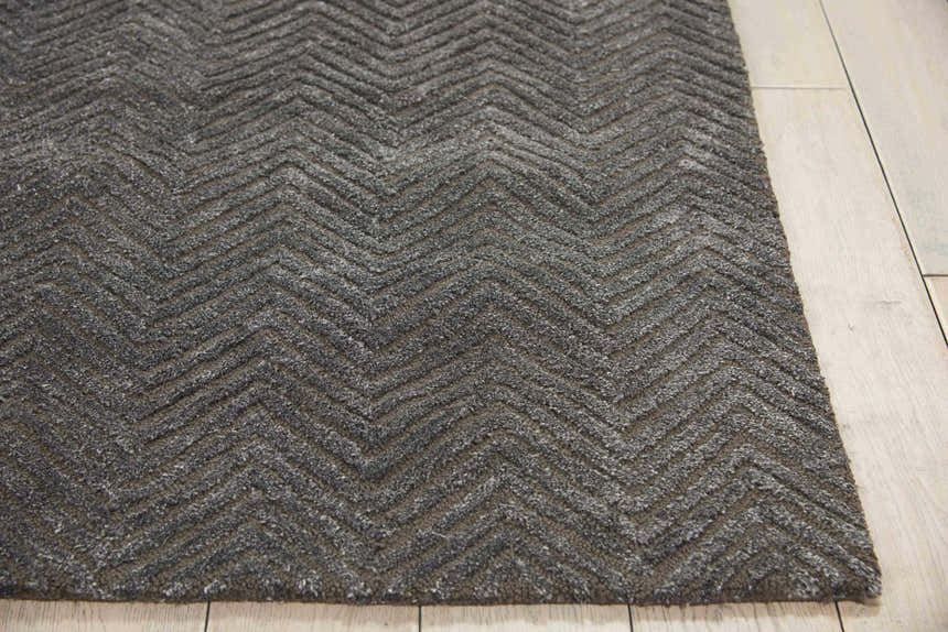Close-up of the grey Nourison Deco Mod rug, featuring a modern, textured chevron pattern on light wood flooring.