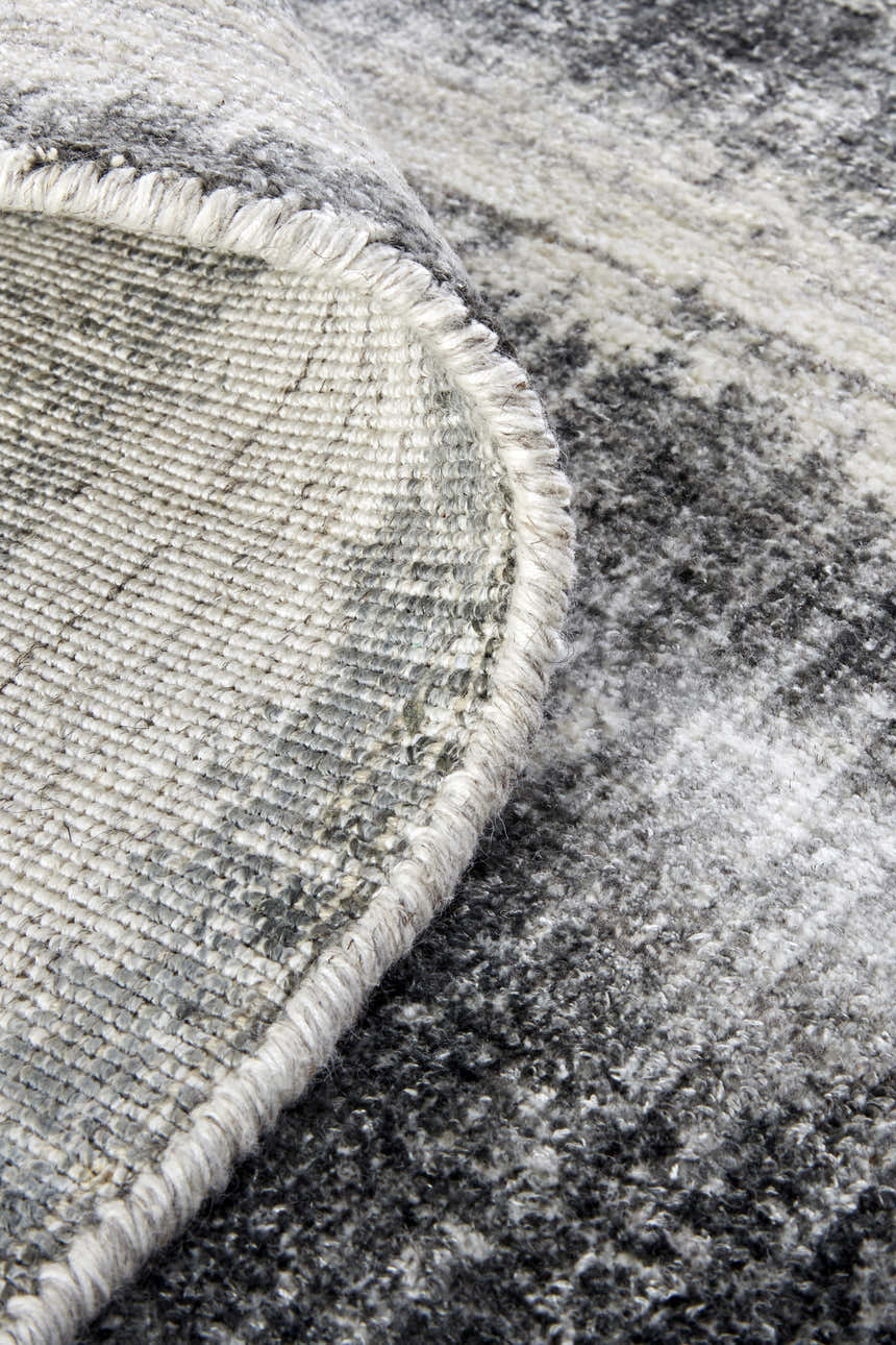 Close-up of Feizy Mackay rug showing gray, ivory, and black stripes and hand-woven texture. Fold