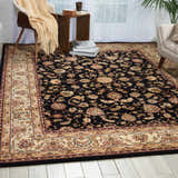 Living room scene with a Nourison 2000 Navy Persian rug, beige furniture, and light wood floors.