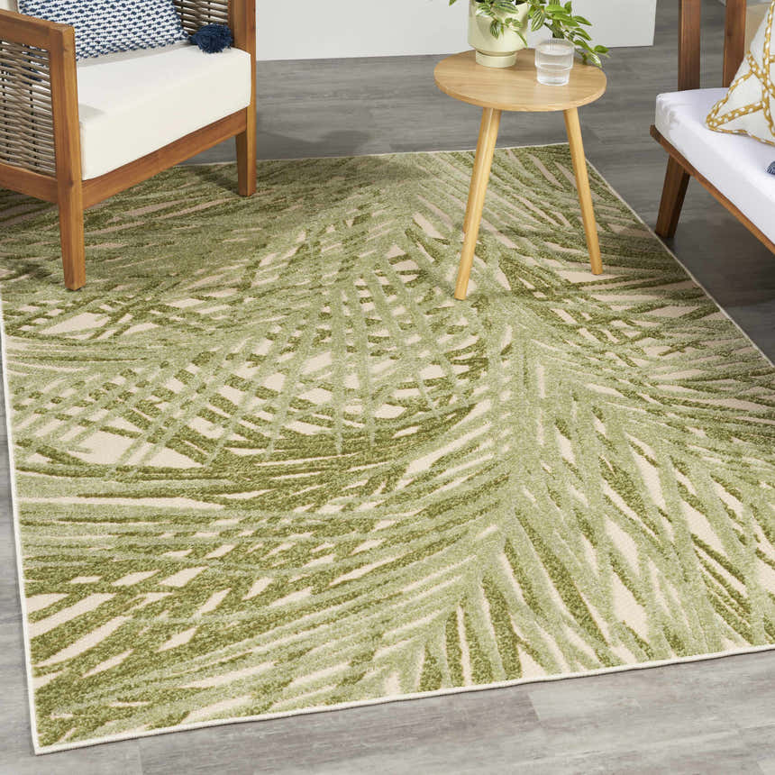 Outdoor patio scene with the Nourison Aloha Ivory Green area rug, wood furniture, and a small side table.