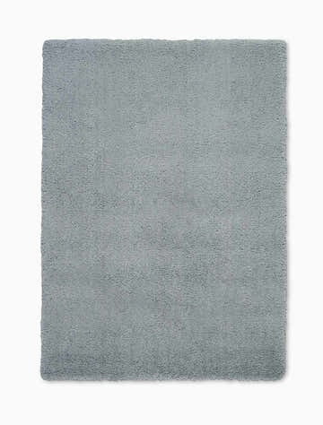 Close-up of the Calvin Klein Chicago Shag rug. The grey rug has a soft, textured, shag pile. Rectangle shape.