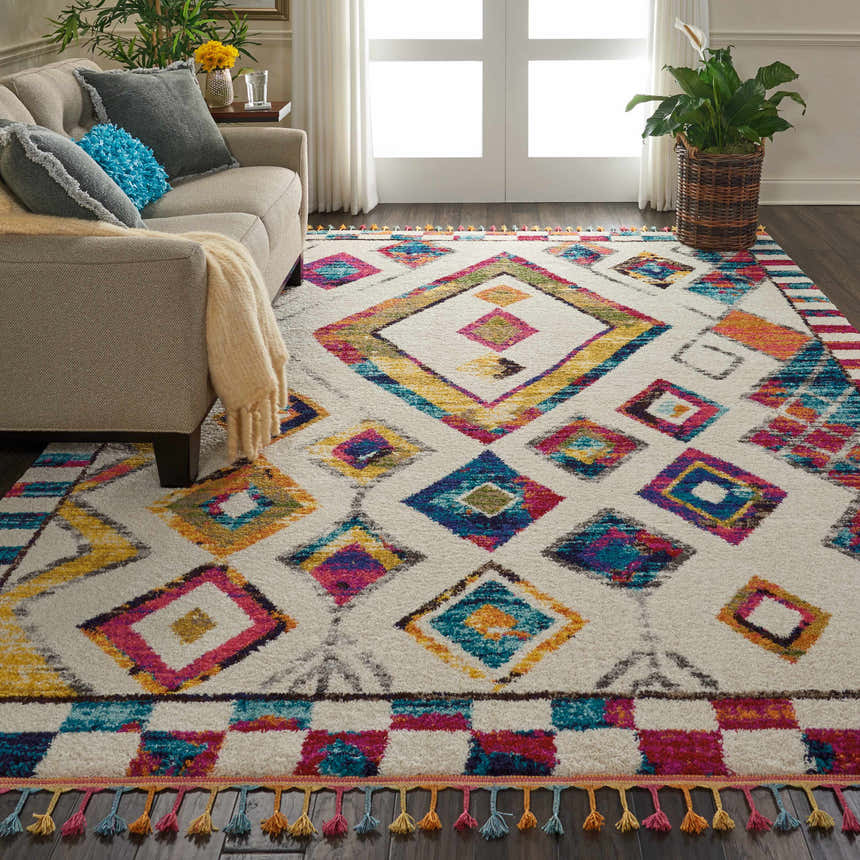 Living room scene with a beige sofa and Nourison Nomad Ivory Multicolor Tribal Area Rug.