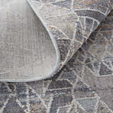 Close-up of Feizy Francisco rug showing gray, blue, and orange abstract pattern and cotton backing. Fold