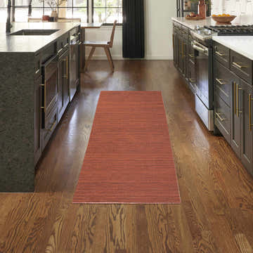 Modern kitchen with a Brick Red Nourison Essentials Washable Area Rug runner on hardwood floors.