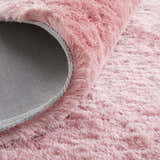 Close-up of the textured, blush pink Feizy Indochine rug, showing its soft pile and durable backing. Fold