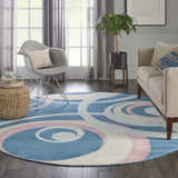 Living room with round Nourison Grafix Blue Multicolor rug, gray chair, tan sofa, and natural light.
