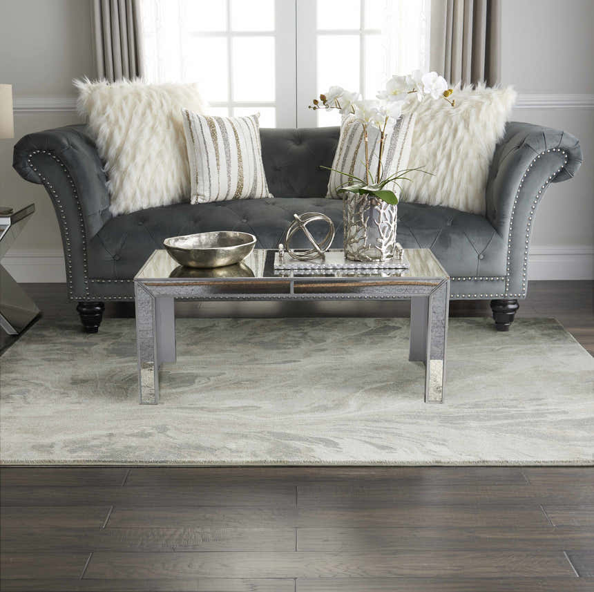 Living room scene with grey sofa, mirrored table, and Inspire Me! Home Décor Elegance Grey rug.