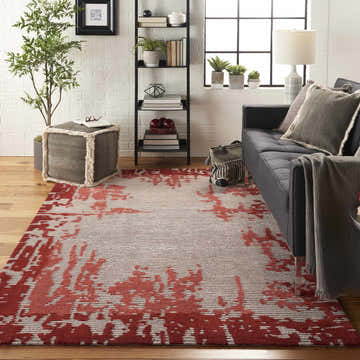 Living room scene with Nourison Symmetry Beige Red rug, gray sofa, wood floors, and modern decor.