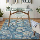 Home office with glass desk and Nourison Tranquil Turquoise Vintage Area Rug with floral pattern.
