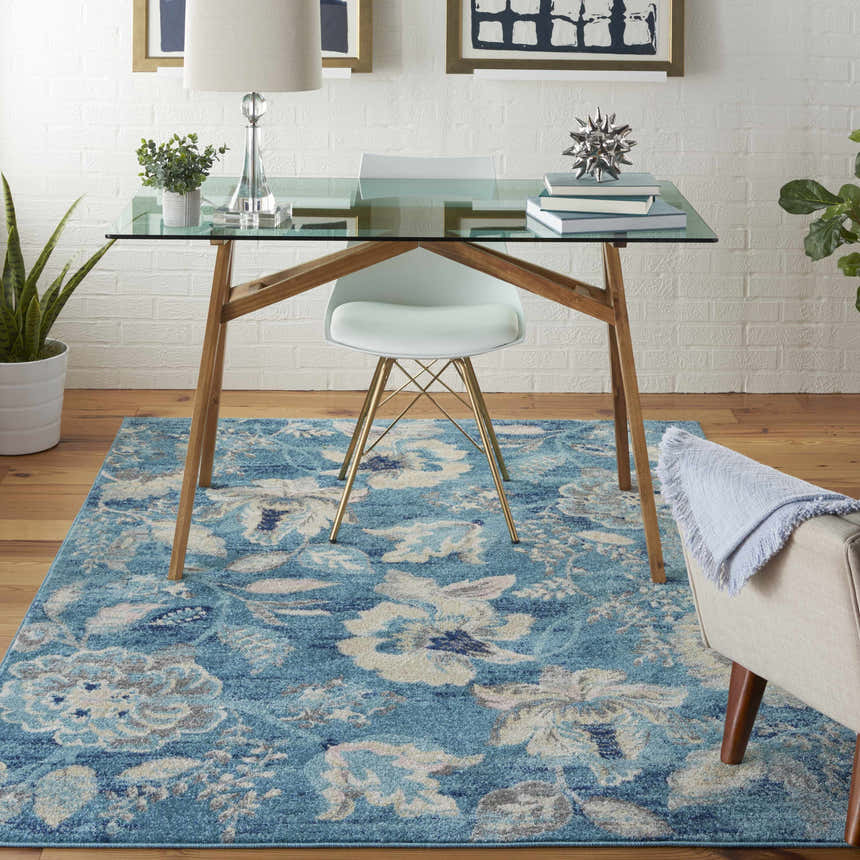 Home office with glass desk and Nourison Tranquil Turquoise Vintage Area Rug with floral pattern.