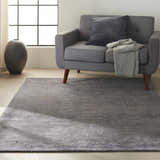 Living room scene with a gray sofa and the Calvin Klein Home Ravine Nightshade area rug.