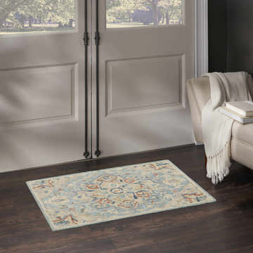 Entryway with Nourison Maison Light Blue Ivory Vintage Indoor Area Rug, dark wood floors, and neutral armchair.