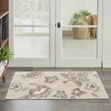 Entryway with Nourison Aloha Beige Farmhouse Area Rug featuring a floral pattern on dark wood floors.