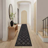 Entryway with Nourison Easy Care Charcoal Black Modern Area Rug runner, wood floors, console table, and arched doorways.