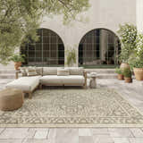 Outdoor patio scene with a neutral sectional and Nourison Tulum Taupe Olive Outdoor Area Rug.