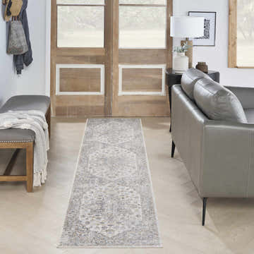 Entryway with gray leather sofa and Nourison Astra Silver Grey Vintage Runner Rug on light wood floors.