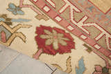 Close-up of the handmade Nourison Nourmak Gold Indoor Area Rug, featuring a floral and geometric design in gold, red, and blue.