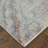 Close-up of Feizy Edgemont Ivory/Orange/Blue Area Rug showing abstract design and soft texture on wood floor. Corner