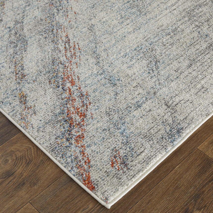 Close-up of Feizy Edgemont Ivory/Orange/Blue Area Rug showing abstract design and soft texture on wood floor. Corner