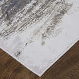 Close-up of Feizy Gaspar rug. Modern abstract design in blue, gray, and white on a distressed, textured surface. Corner