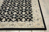 Close up of the Nourison Persian Empire Black Persian rug's floral pattern and border on wood floors.