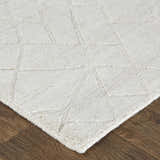 Close up of the ivory and gray Feizy Redford rug showing its geometric pattern and hand woven texture. Corner