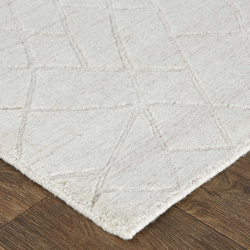 Close up of the ivory and gray Feizy Redford rug showing its geometric pattern and hand woven texture. Corner