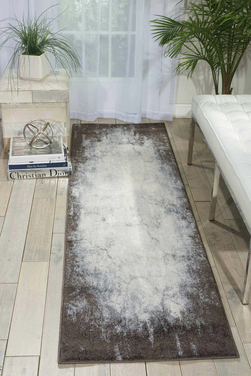 Modern living room scene with a Nourison Maxell Ivory Grey rug, white bench, wood floors, and plants.