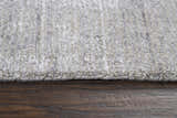 Close-up of the textured Rizzy GH718A area rug in beige, gray, and ivory on a wood floor. Pile