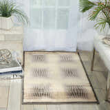 Modern living room with a Nourison Utopia Shell rug, white furniture, and plants.