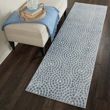 Entryway with Nourison Urban Chic Light Blue runner rug, dark wood floors, and upholstered bench with blue throw.