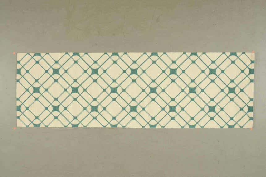 Close-up of Nourison Enhance Ivory/Turquoise runner rug, featuring a geometric diamond pattern. Chestnut accents.