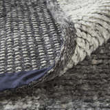 Close-up of the Feizy Alford rug showing the ivory and gray geometric pattern and hand-knotted wool texture. Fold