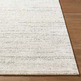 Close-up of the Sezja Beige Luxe Area Rug showing its textured, horizontal line pattern in beige, cream, and black. Front