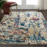 Living room scene with Nourison Fusion Cream Multicolor rug, wood floors, and a leather stool.