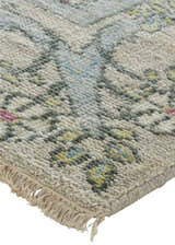 Close-up of the hand-knotted Feizy Beall rug. Ivory wool rug with a traditional floral pattern in pink, green, and blue. Corner
